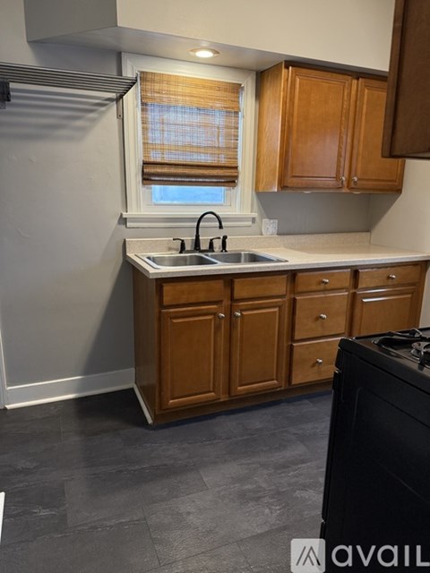 A kitchen with wooden cabinets and a black dishwasher.