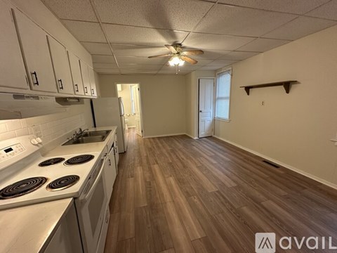 A kitchen with white cabinets and a wooden floor.
