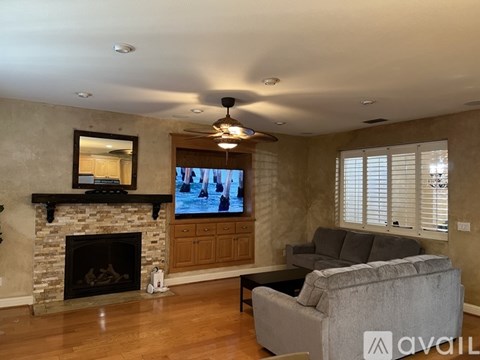 A living room with a fireplace and a television on the wall.