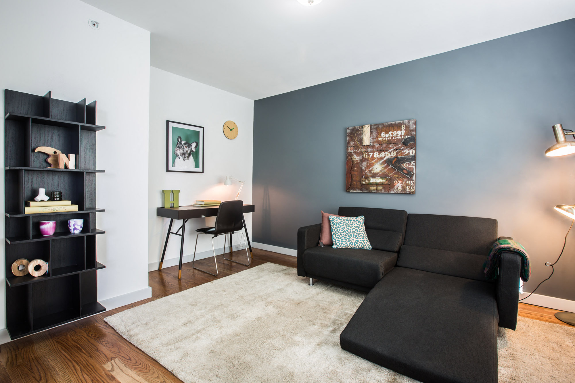 a living room with a couch and a chair and a desk