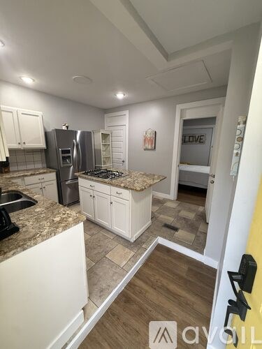 A kitchen with white cabinets and a granite countertop.