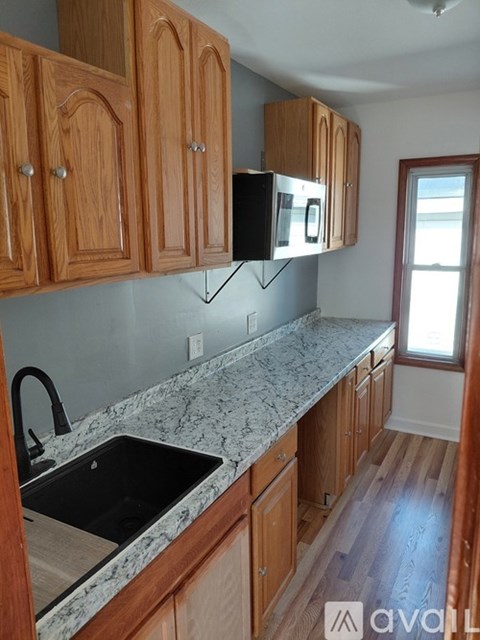 A kitchen with wooden cabinets and granite countertops.