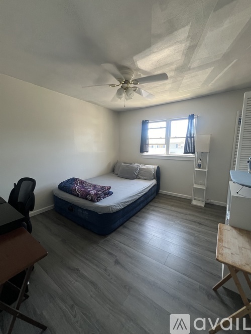 A room with a bed, a desk, and a chair.