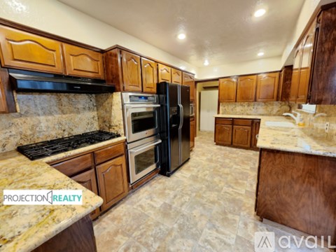 A kitchen with granite countertops and wooden cabinets is available for rent.