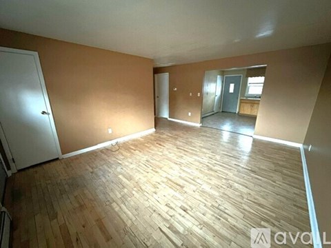 A room with wooden flooring and a door is available.
