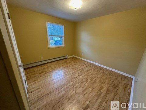 A room with wooden flooring and a window.