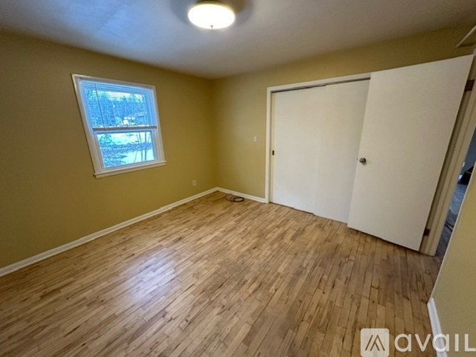 A room with wooden flooring and a window.