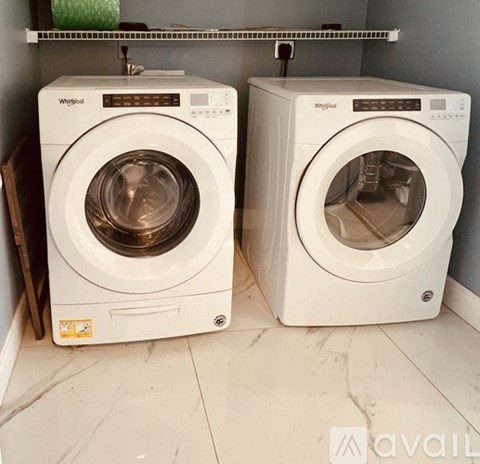 Two Whirlpool washing machines in a laundry room.