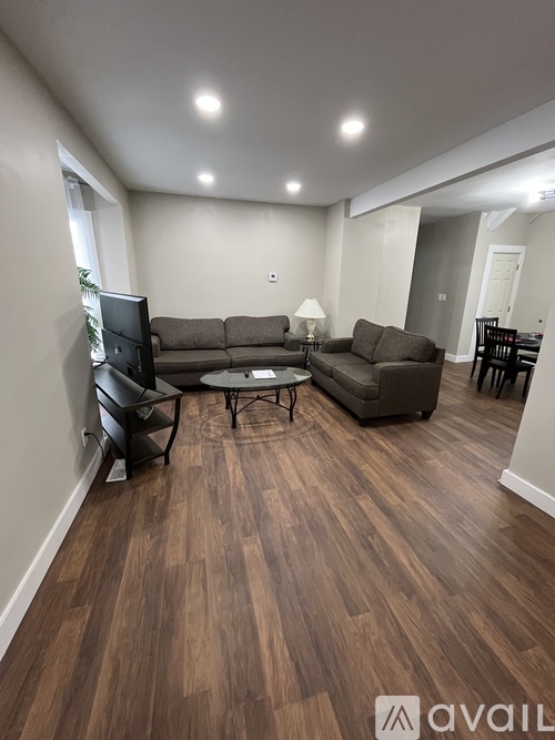 A living room with a brown sofa and a black chair.