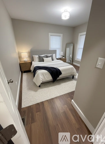 A bedroom with a bed, nightstands, and a rug.