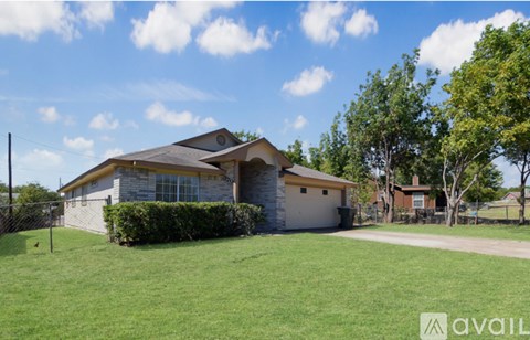 A house with a fence and green grass in front.