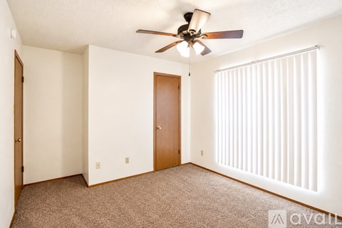 A room with two doors and a ceiling fan.
