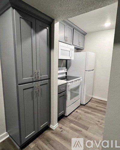 A kitchen with a refrigerator, oven, and microwave.