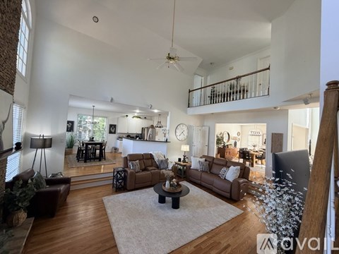A living room with brown leather couches and a white rug.