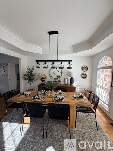 A dining room with a wooden table set for six people.