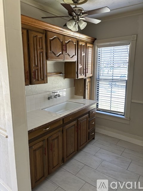 A kitchen with wooden cabinets and a white sink.