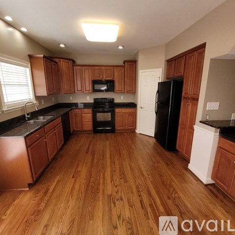 A kitchen with wooden cabinets and black appliances.