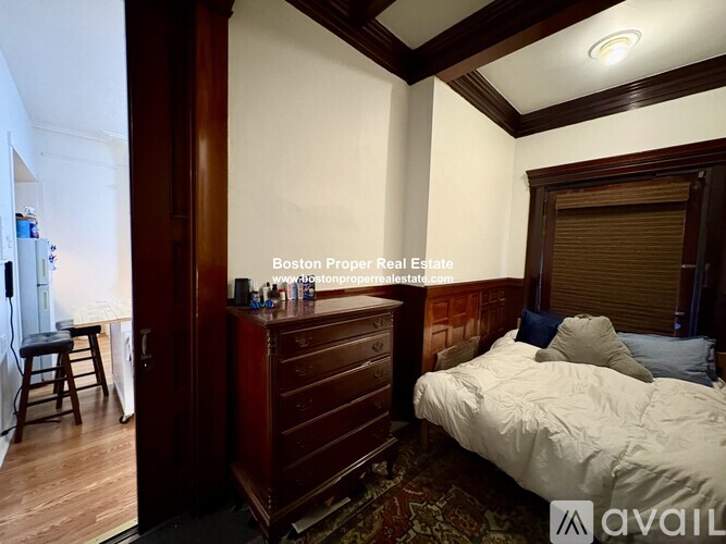 A bedroom with a bed, dresser, and window with blinds.