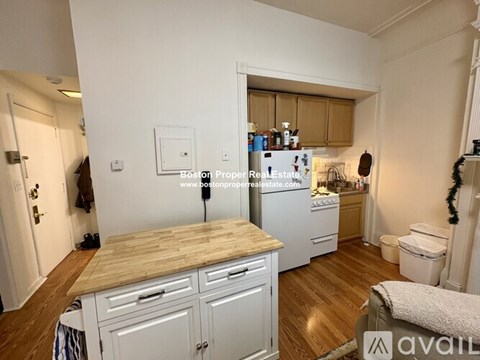A kitchen with wooden cabinets and a white fridge.