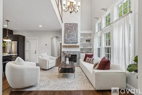 A living room with a white sofa, a coffee table, and a chandelier.