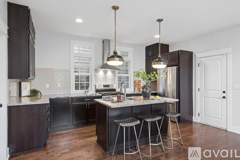 A kitchen with a black refrigerator and a white countertop.