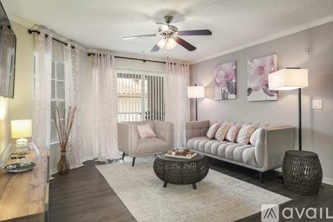 A living room with a sofa, a table, and a ceiling fan.