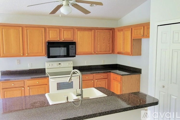 A kitchen with a black microwave above a white sink.