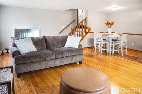 A living room with a grey couch and a wooden floor.