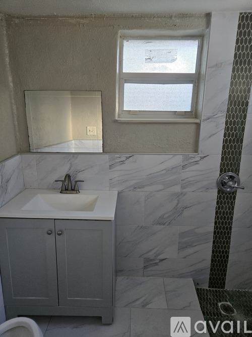 A bathroom with a marble sink and a window.