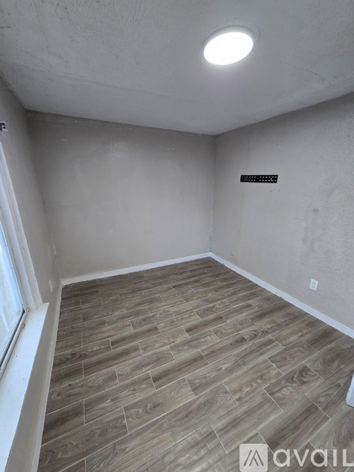 A room with wooden flooring and a light on the ceiling.
