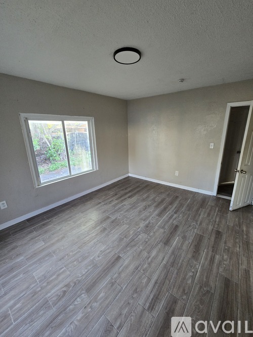 A room with a grey floor and a window.