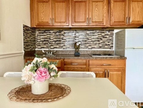 A kitchen with wooden cabinets and a marble backsplash.