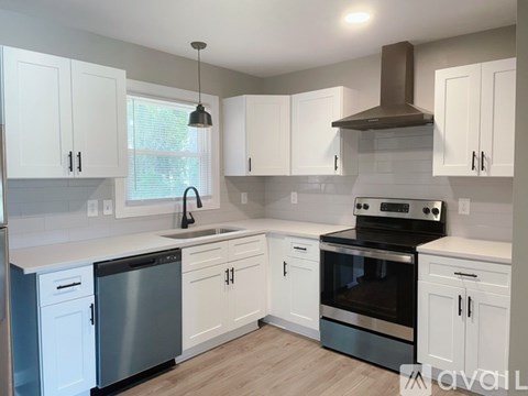 A kitchen with white cabinets and a stainless steel dishwasher.