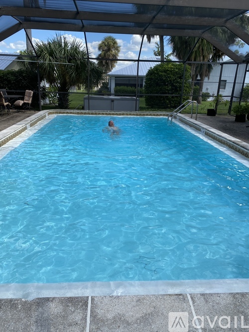A person is swimming in a pool with a tiled floor.