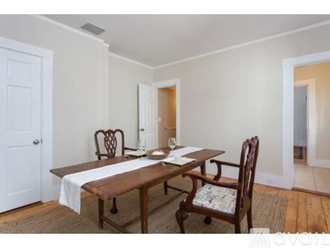 A dining room with a wooden table and chairs.