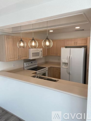 A kitchen with wooden cabinets and a white refrigerator.