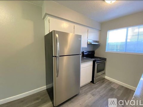 A kitchen with a stainless steel refrigerator and a black stove top oven.