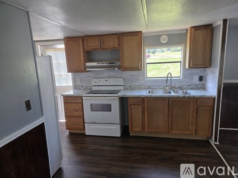 A kitchen with wooden cabinets and white appliances.