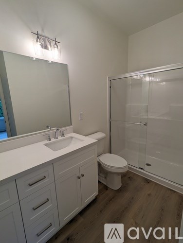 A bathroom with a sink, toilet, and shower.