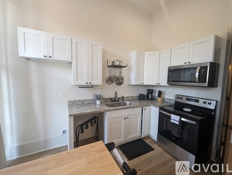 A kitchen with white cabinets and a black stove top oven.