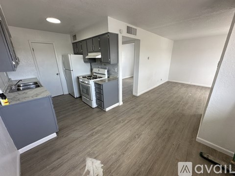 A kitchen with a stove top oven and a refrigerator.