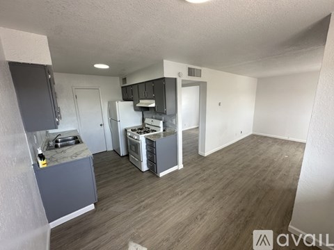 A kitchen area with a refrigerator, oven, and sink.