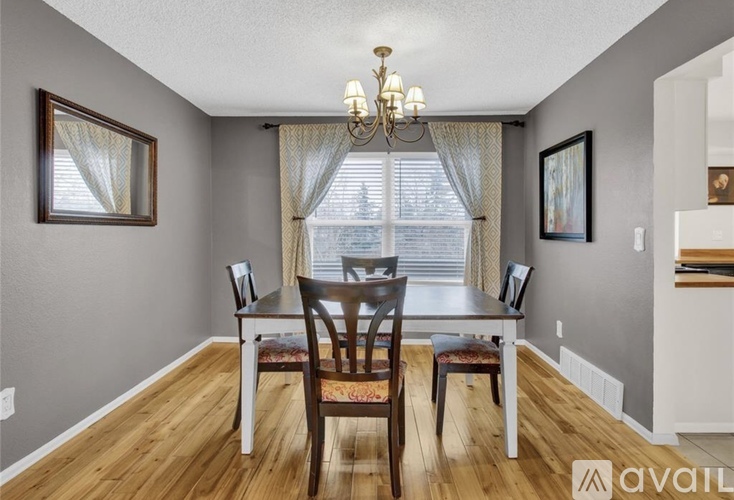 A dining room with a wooden table and chairs.