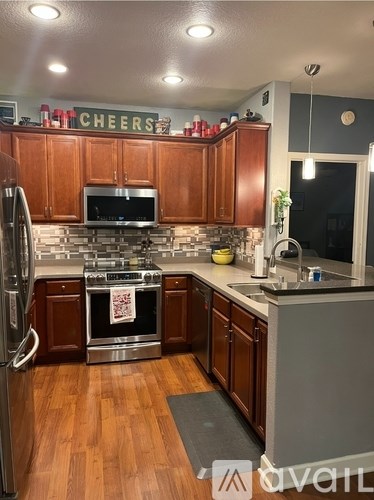 A kitchen with wooden cabinets and a stainless steel refrigerator.