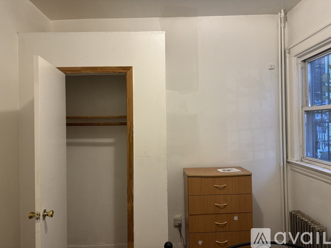 A room with a white wall and a wooden door.