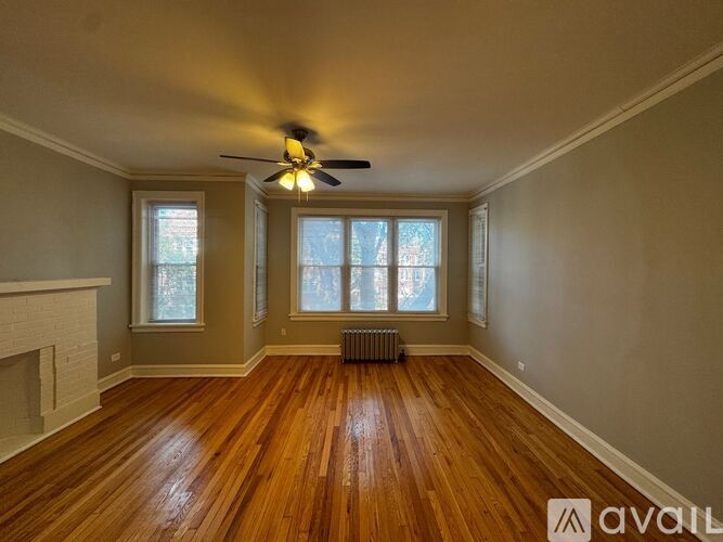 A room with a ceiling fan and wooden flooring.