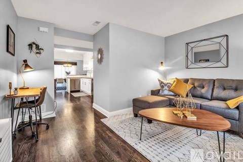 A living room with a grey couch and a wooden coffee table.