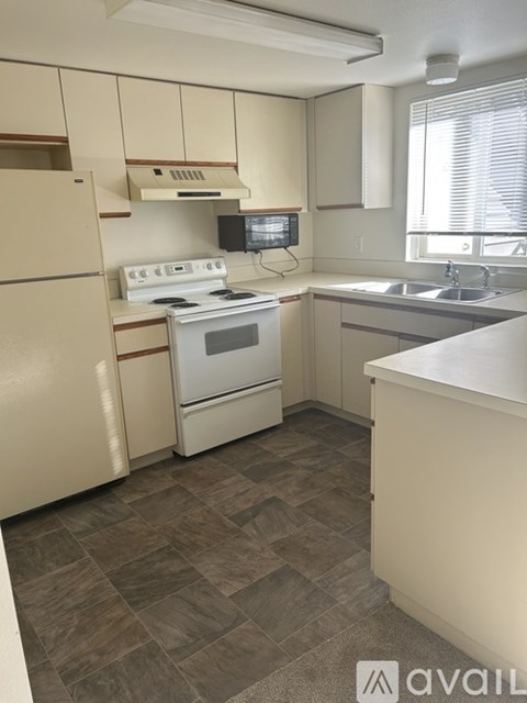 A kitchen with a refrigerator, stove, oven, and microwave.