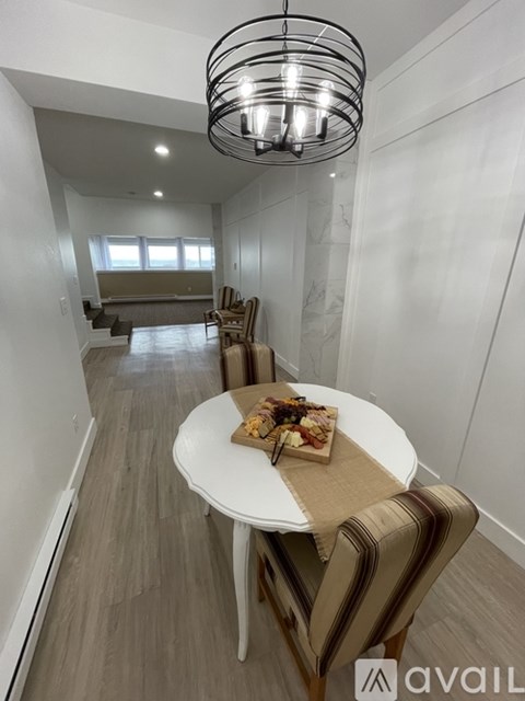 A modern dining area with a round table and striped chairs.