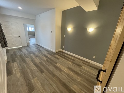 A room with wood flooring and a white door.